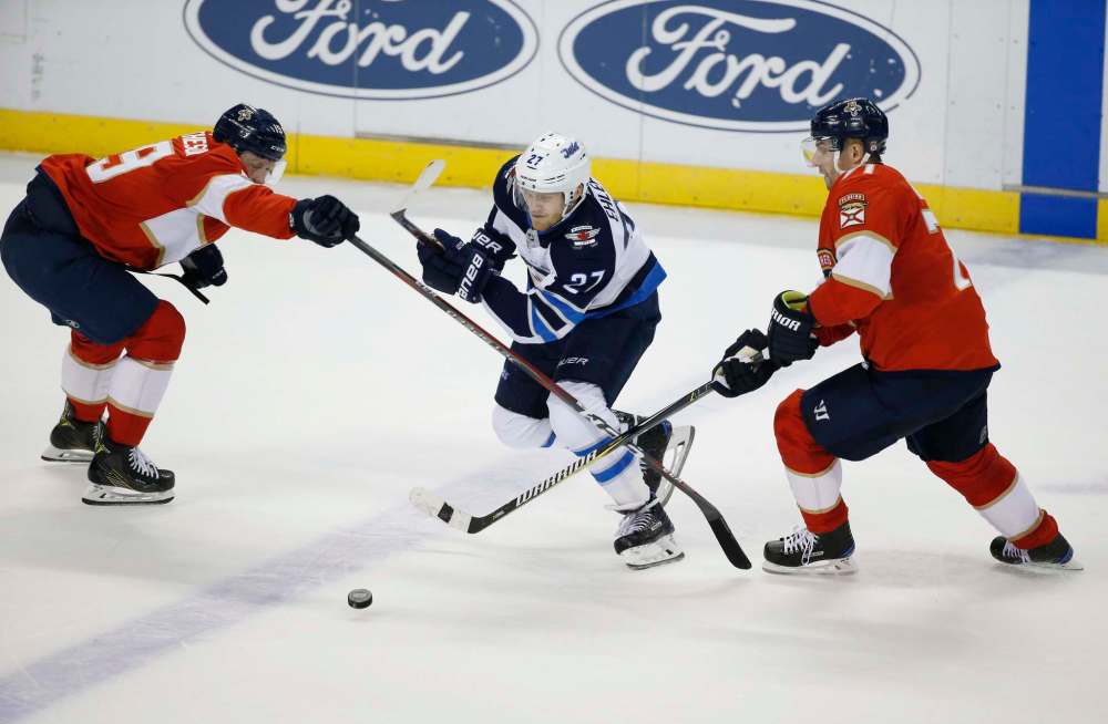 AP Photo/Wilfredo Lee
Winnipeg Jets winger Nikolaj Ehlers drives between two during the second period, Thursday in Sunrise, Fla.