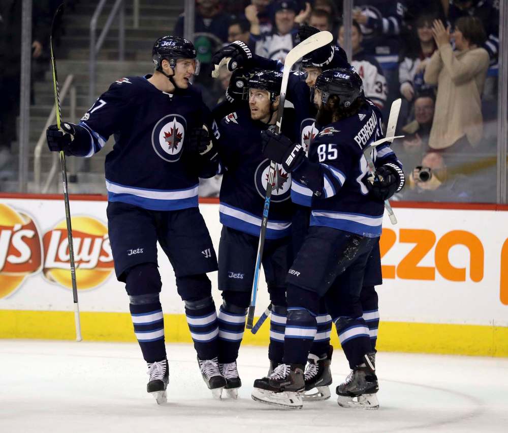 Trevor Hagan / The Canadian Press Filese
Winnipeg Jets’ Tyler Myers (57), Bryan Little celebrate after Perreault’s goal during second period NHL hockey action against the Vancouver Canucks, in Winnipeg on Monday.