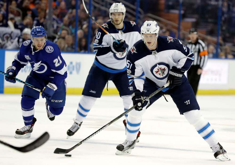 Winnipeg Jets defenseman Tyler Myers (57) skates past teammate Joel Armia (40) and Tampa Bay Lightning center Brayden Point (21) during the first period of an NHL hockey game Saturday, Dec. 9, 2017, in Tampa, Fla. (AP Photo/Chris O'Meara)