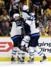 Winnipeg Jets center Adam Lowry (17), center Andrew Copp (9) and defenseman Dmitry Kulikov (5) celebrate after Brandon Tanev scored the go-ahead goal against the Nashville Predators in the third period of an NHL hockey game Tuesday, Dec. 19, 2017, in Nashville, Tenn. The Jets won 6-4. (Mark Humphrey / The Associated Press files)