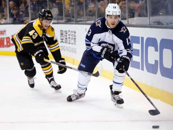 (AP Photo/Michael Dwyer)Boston Bruins' Danton Heinen (43) battles Winnipeg Jets' Brandon Tanev (13) for the puck during the second period of an NHL hockey game in Boston, Thursday, Dec. 21, 2017.