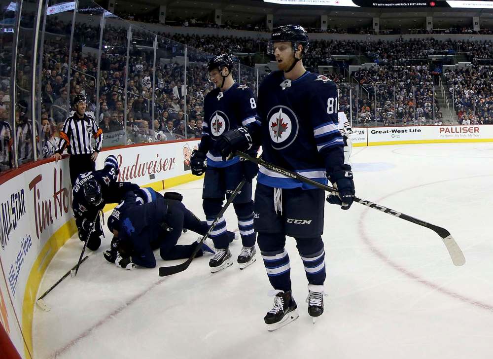 TREVOR HAGAN / WINNIPEG FREE PRESS
Winnipeg Jets' Mark Scheifele (55) lays on the ice after being injured while playing against the Edmonton Oilers' during second period.