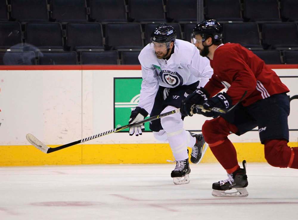 RUTH BONNEVILLE / WINNIPEG FREE PRESS
Winnipeg Jets captain Blake Wheeler (left, racing defenceman Julian Melchiori at practice Thursday) said No. 1 centre Mark Scheifele’s absence will be felt. He was injured in Wednesday’s game against the Edmonton Oilers.