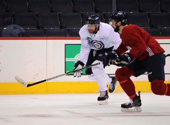 RUTH BONNEVILLE / WINNIPEG FREE PRESSWinnipeg Jets captain Blake Wheeler (left, racing defenceman Julian Melchiori at practice Thursday) said No. 1 centre Mark Scheifele’s absence will be felt. He was injured in Wednesday’s game against the Edmonton Oilers.