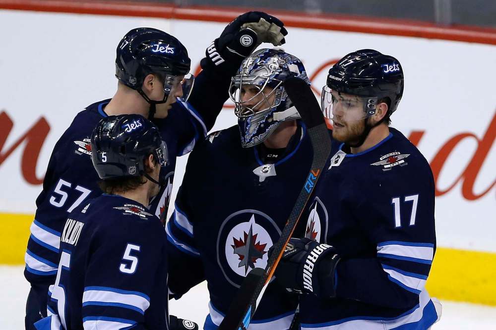 THE CANADIAN PRESS/John Woods
Winnipeg Jets players congratulate goaltender Connor Hellebuyck for a win over the Edmonton Oilers. Hellebuyck has been outstanding in goal for the Jets over the last week going 3-0 and pushing his record this season to 21-4-5.