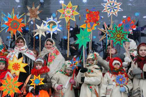 Ukrainians in folk costumes hold symbols of the star of Bethlehem as they celebrate Orthodox Christmas in central Kiev, Ukraine, Saturday, Jan. 7 2017. (AP Photo/Efrem Lukatsky)