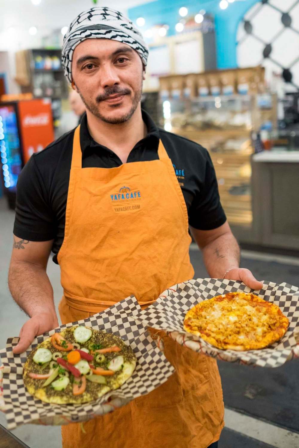 Daniel Crump / Winnipeg Free Press
Ahmed Salama, a Syrian refugee who found work at Yafa Café, holds Za’atar (left) and Shakshuka & Sunny Eggs (right) that he just prepared.