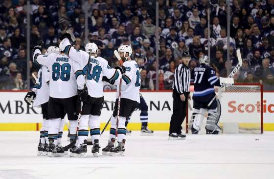 San Jose Sharks players celebrate after Logan Couture (39) scored on Winnipeg Jets goaltender Connor Hellebuyck (37) during second period NHL hockey action in Winnipeg, Sunday, January 7, 2018. THE CANADIAN PRESS/Trevor Hagan