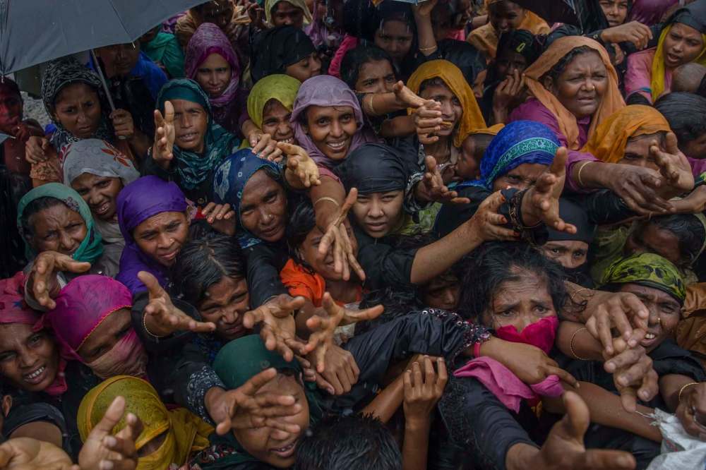 Dar Yasin / The Associated Press Files
Rohingya Muslim women, who crossed over from Myanmar into Bangladesh, stretch their arms out to collect aid distributed near the Balukhali refugee camp.