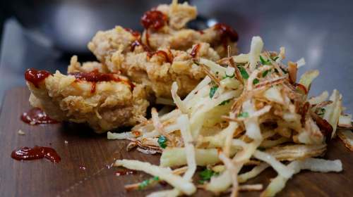 Carnita (456 Main St.) drizzles its fried chicken thighs with guajillo sauce and adds a side of green papaya frito.
