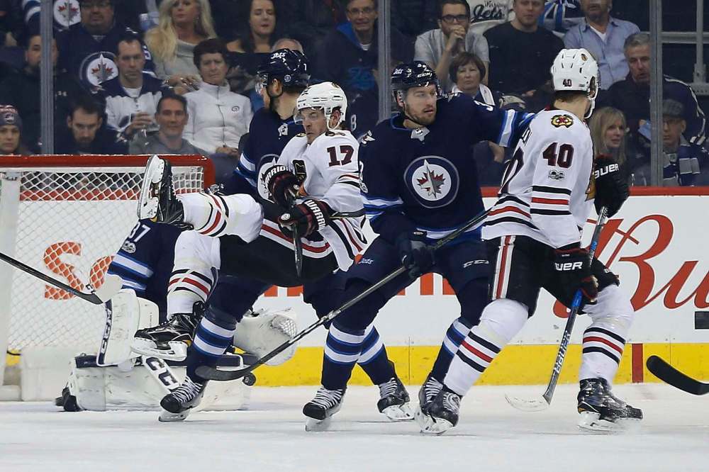 John Woods / The Canadian Press files
Winnipeg Jets defencemen Ben Chiarot (left) and Tucker Poolman clear traffic in front of goalie Connor Hellebuyck during a game against the Chicago Blackhawks in December.