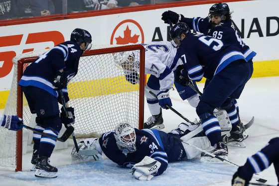 JOHN WOODS / WINNIPEG FREE PRESSWinnipeg Jets goalie Michael Hutchinson makes a save against Tampa Bay Lightning's Yanni Gourde as Jets' Josh Morrissey, Tyler Myers and Mathieu Perreault defend during first period .