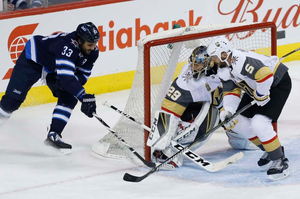 JOHN WOODS / THE CANADIAN PRESS
Winnipeg Jets' Dustin Byfuglien (33) attempts the wraparound on Vegas Golden Knights goaltender Marc-Andre Fleury (29) and Deryk Engelland (5) during first period NHL action in Winnipeg on Thursday, February 1, 2018.