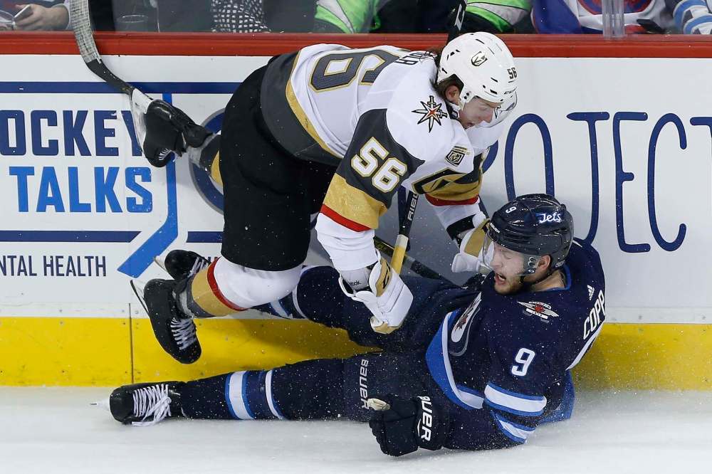 Vegas Golden Knights Erik Haula (56) and Winnipeg Jets' Andrew Copp (9) collide during third period NHL action in Winnipeg on Thursday, February 1, 2018. THE CANADIAN PRESS/John Woods