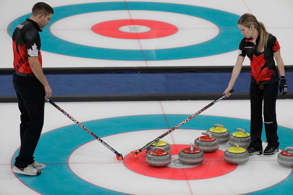 Aaron Favila / The Associated Press
Canada's John Morris, left, and Kaitlyn Lawes plan their next move during their mixed doubles curling match against Norway at the 2018 Winter Olympics in Gangneung, South Korea on Thursday.