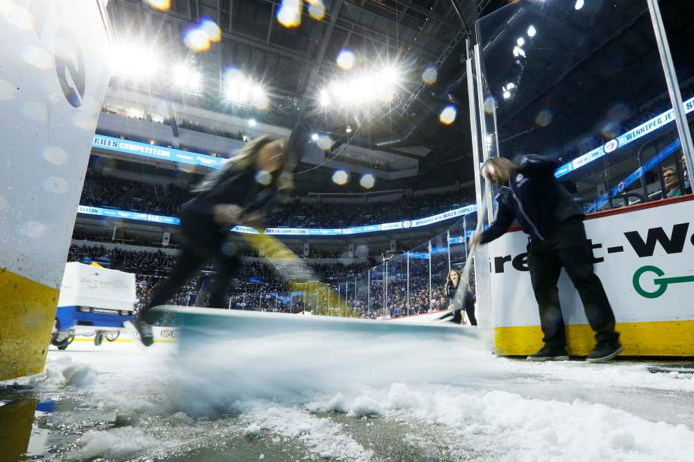 Members of the Ice Crew dump snow as they skate by the entrance.