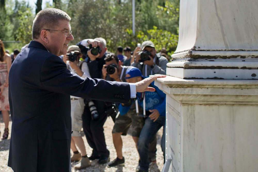 Petros Giannakouris / The Associated Press files
IOC president Thomas Bach touches a monument to Pierre de Coubertin in ancient Olympia, southern Greece. It’s not clear if Coubertin would recognize the current incarnation of the Olympics.