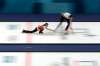 Canada's Kaitlyn Lawes throws a stone as teammate John Morris begins to sweep ice during the mixed doubles curling match Saturday. (Aaron Favila / The Associated Press)