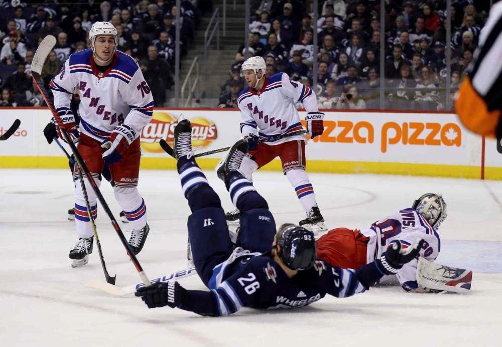 Trevor Hagan / The Canadian Press
Winnipeg Jets' Blake Wheeler (26) crashes into New York Rangers goaltender Henrik Lundqvist (30) during second period NHL hockey action in Winnipeg, Sunday, February 11, 2018.