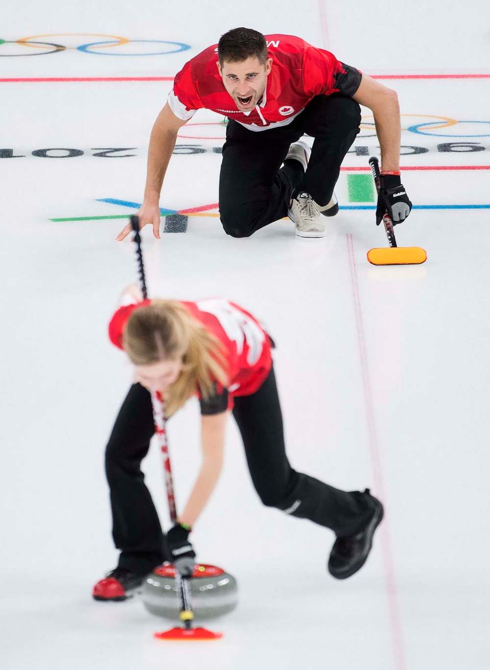 Nathan Denette / THE CANADIAN PRESS
John Morris reacts as Kaitlyn Lawes sweeps during mixed doubles curling action against Switzerland.