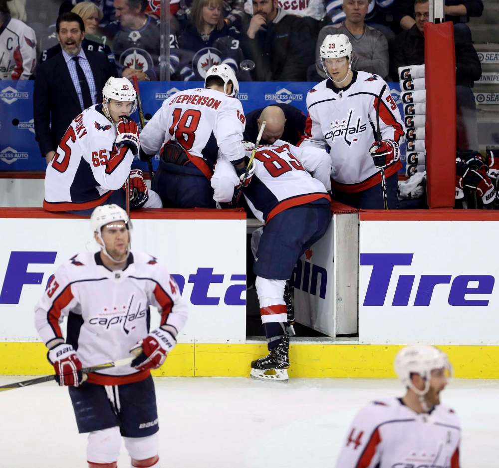 Jay Beagle leaves the ice after being slashed by Dustin Byfuglien. (Trevor Hagan / The Canadian Press)