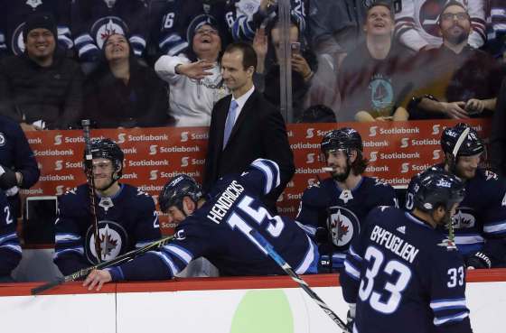 Matt Hendricks imitates shooting a pool cue as Blake Wheeler (not shown) returns to the bench after a goal scored using his hand was disallowed against the Florida Panthers Sunday night. (Trevor Hagan / The Canadian Press)