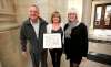 Shelley Armstrong, middle, with her father, George, left, was recognized for the family's work on the Langside Grocery by Lisa Gardewine, Heritage Winnipeg President. (Trevor Hagan / Winnipeg Free Press)
