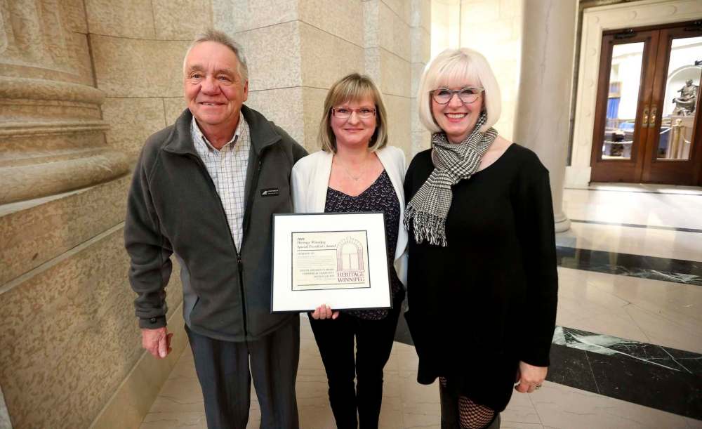 Shelley Armstrong, middle, with her father, George, left, was recognized for the family's work on the Langside Grocery by Lisa Gardewine, Heritage Winnipeg President. (Trevor Hagan / Winnipeg Free Press)