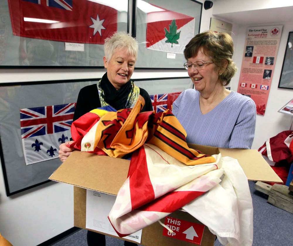 BORIS MINKEVICH / WINNIPEG FREE PRESS
Joan Grandmont and Carol Morgan open a box of donated flags at the Argyle museum.