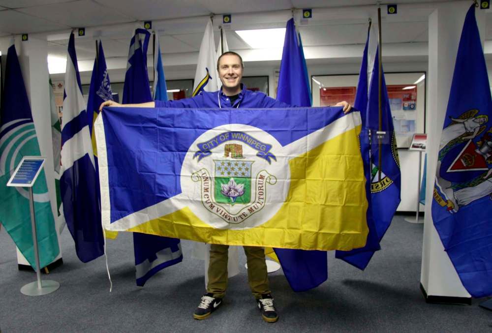 SUPPLIED
Shayne Campbell, president of the Settlers, Rails & Trails Museum, holds an old City of Winnipeg flag.