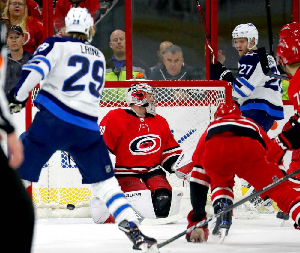Chris Seward / Raleigh News & Observer files
The Winnipeg Jets’ Patrik Laine (left) puts the puck past Carolina Hurricanes goalie Cam Ward while Nikolaj Ehlers looks on during a game on March 4 in Raleigh, N.C.