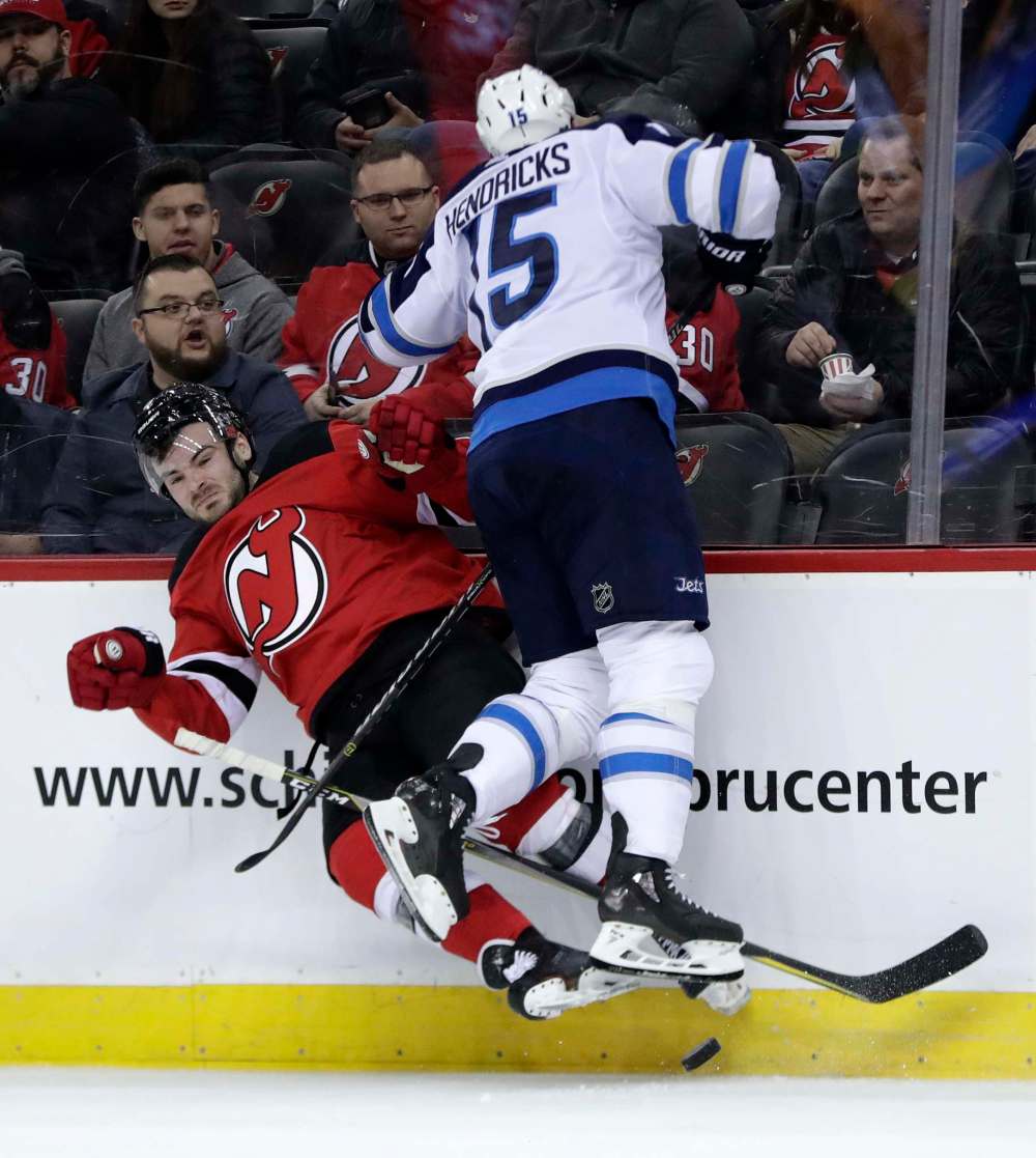 (AP Photo/Julio Cortez)
New Jersey Devils defenseman Will Butcher, left, is checked by Winnipeg Jets center Matt Hendricks during the second period of an NHL hockey game, Thursday, March 8, 2018, in Newark, N.J.