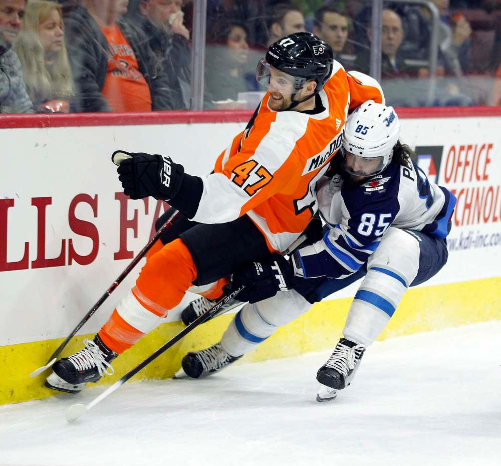 Andrew MacDonald, left, and Mathieu Perrault vie for the puck during the first period (Tom Mihalek / The Associated Press)