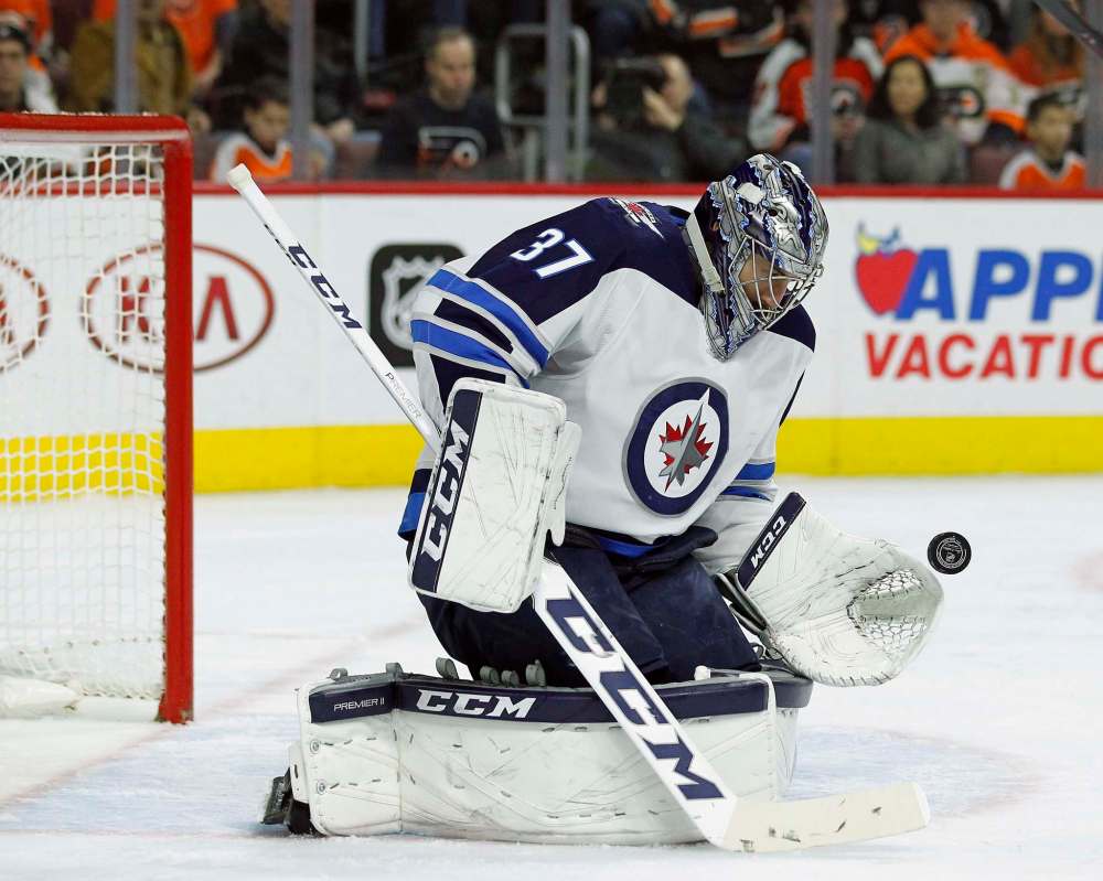 Connor Hellebuyck gloves a shot on goal during the second period. (Tom Mihalek / The Associated Press)