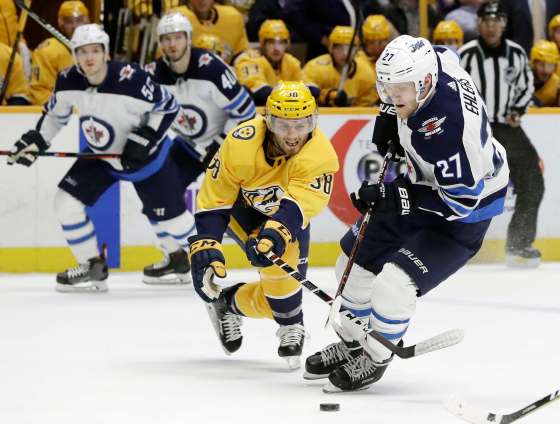 AP Photo/Mark HumphreyWinnipeg Jets left wing Nikolaj Ehlers moves the puck against Nashville Predators right wing Ryan Hartman in the first period Tuesday in Nashville.