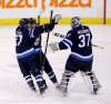 Trevor Hagan / The Canadian Press
Winnipeg Jets Nikolaj Ehlers (left) and Mark Scheifele rush to goaltender Connor Hellebuyck (37) after he made the game-winning save against the Nashville Predators Sunday.