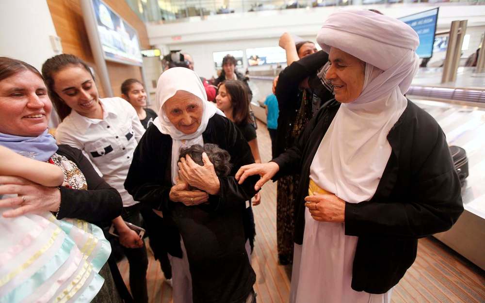 Family matriarch Shireen Khudida, the matriarch and the last of Operation Ezra's Yazidi families, is welcomed at Richardson International Airport Thursday by her daughter Base Qave right. (Phil Hossack / Winnipeg Free Press)