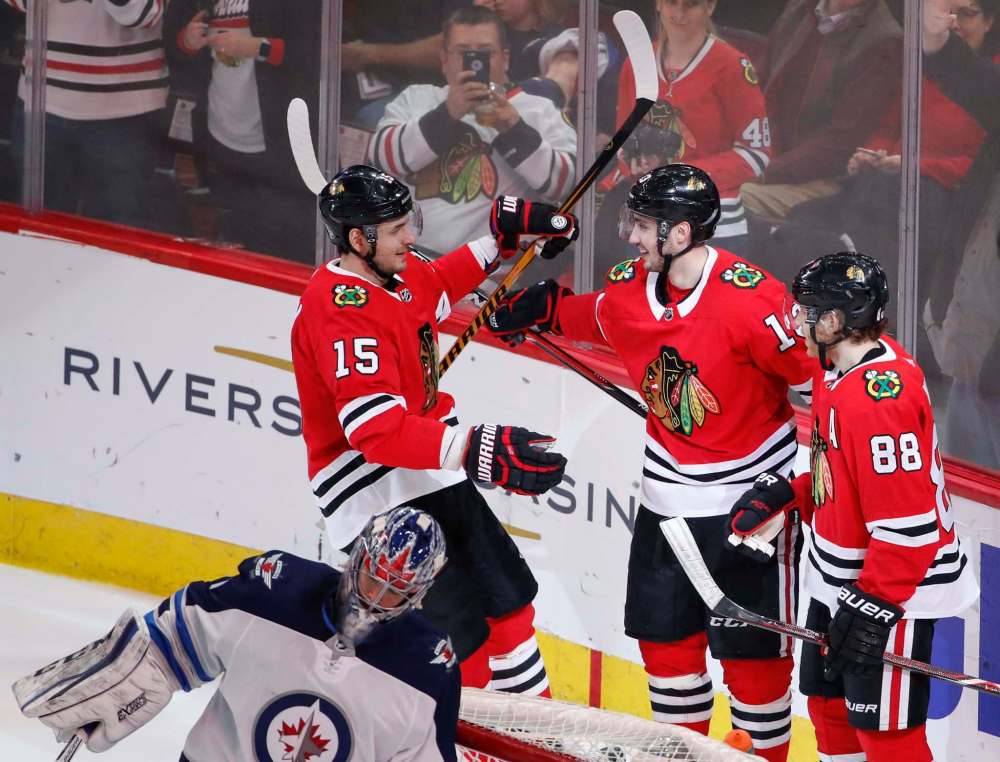 Kamil Krzaczynski / The Associated Press
Chicago Blackhawks left wing Tomas Jurco (13) celebrates with centre Artem Anisimov (15) and right wing Patrick Kane (88) after scoring against the Winnipeg Jets during the second period of an NHL hockey game Thursday. Blackhawks won 6-2.