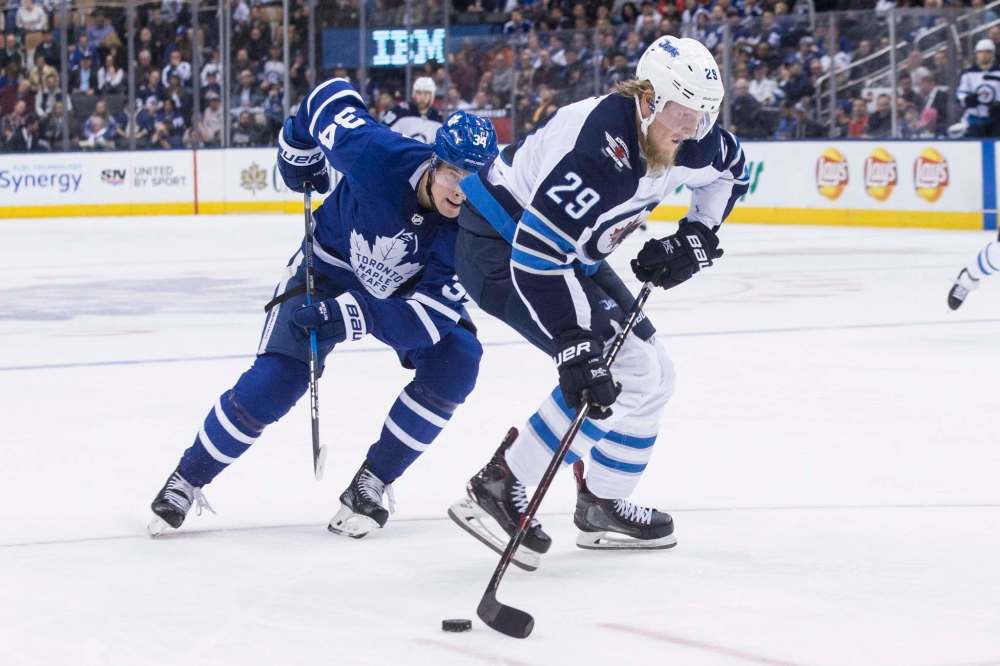 CHRIS YOUNG / THE CANADIAN PRESS
Winnipeg Jets' Patrik Laine (29) brings the puck forward as Toronto Maple Leafs' Auston Matthews (34) pursues him during third period NHL hockey action in Toronto on Saturday, March 31, 2018.