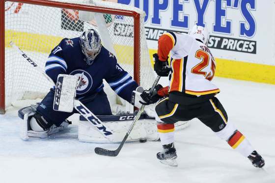 THE CANADIAN PRESS/John WoodsWinnipeg Jets goaltender Connor Hellebuyck saves a breakaway attempt by Calgary Flames' Nick Shore.