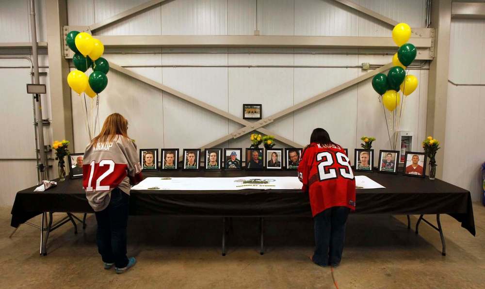 Virden Oil Capitol fans sign a tribute card to the Humbolt Broncos at the Virden Tundra Oil Gas Place Thursday. (Phil Hossack / Winnipeg Free Press)