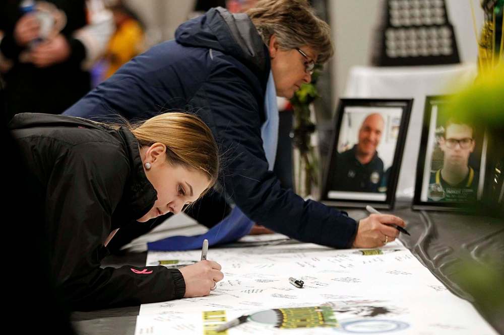 Fans sign a tribute card for Broncos players, which will be sent to Humboldt. It was one gesture of many to honour the crash victims. (Phil Hossack / Winnipeg Free Press)