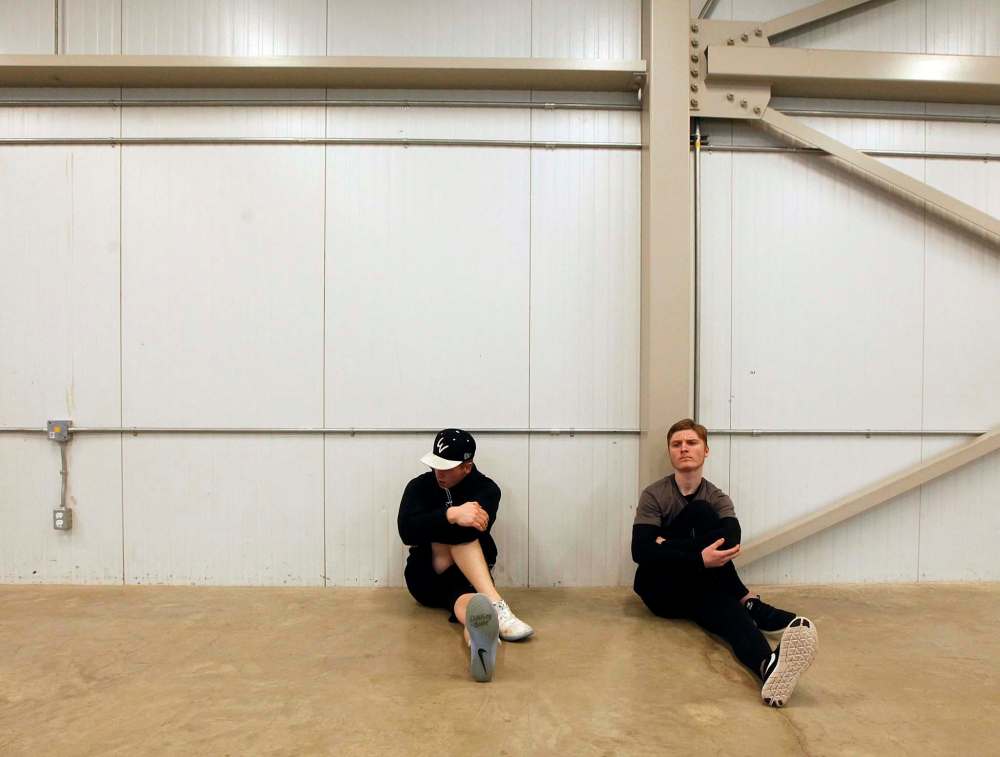 Virden Oil Capitals Dalton Dosch (left) and Garret Sambrook use an out of the way corner on the concourse at the Virden Tundra Oil Gas Place to have a pre game stretch Thursday. (Phil Hossack / Winnipeg Free Press)