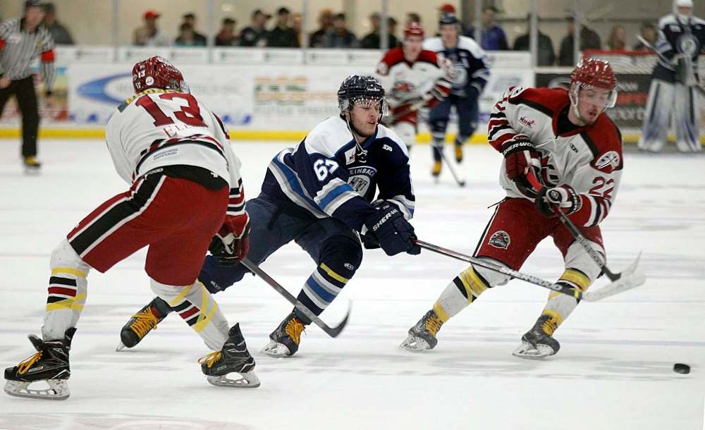 Steinbach Pistons work for the puck on a drive between Virden Oil Capitals Devon Becker and Rylee Zimmer, Thursday. (Phil Hossack / Winnipeg Free Press)