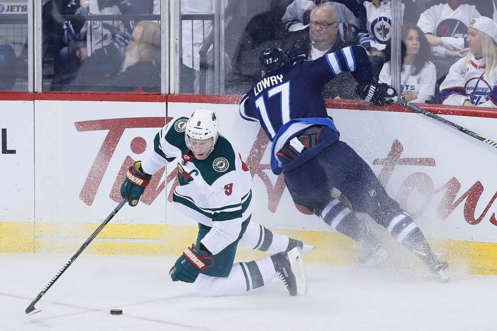 Mikko Koivu battles Adam Lowry for a loose puck last Friday. (John Woods / Canadian Press files)
