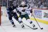 Lowry attempts to steal the puck from Minnesota Wild's Matt Dumba Friday night. (John Woods / The Canadian Press)