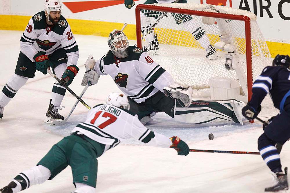 PHIL HOSSACK / WINNIPEG FREE PRESS
Minnesota Wild goalie Devan Dubnyk stretches out a pad to stop the puck as Winnipeg Jets' Joel Armia closes in on the rebound.