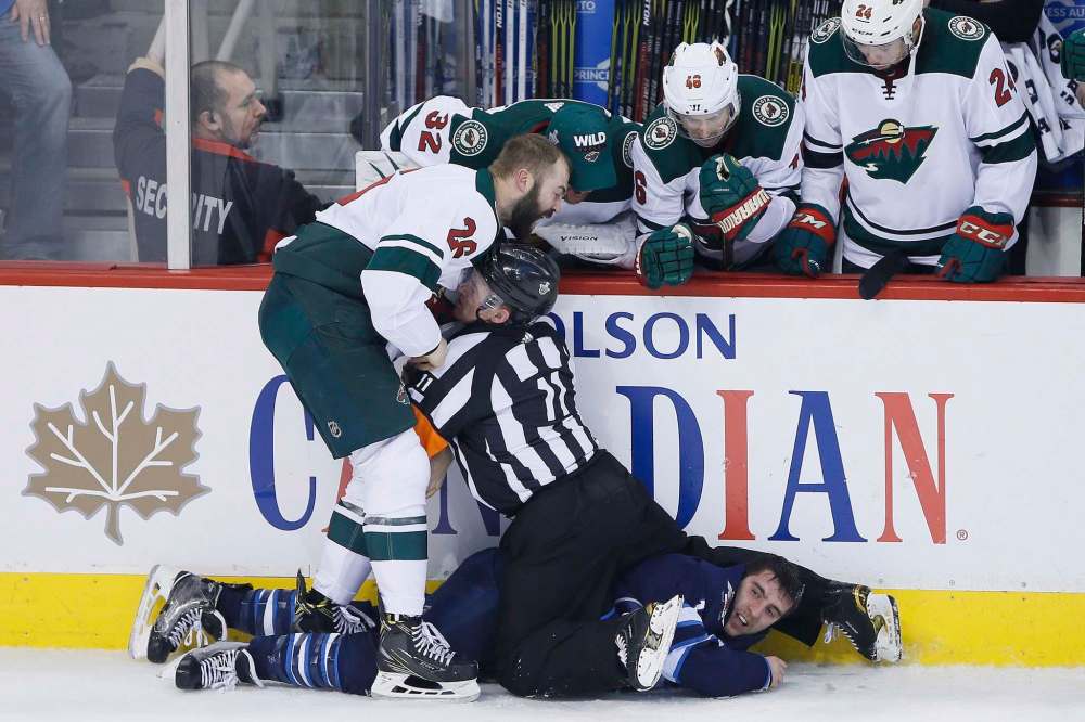 THE CANADIAN PRESS/John Woods
Referree Kelly Sutherland attempts to breakup a fight between Minnesota Wild's Daniel Winnik and Winnipeg Jets' Brandon Tanev in the final minutes of the third period.