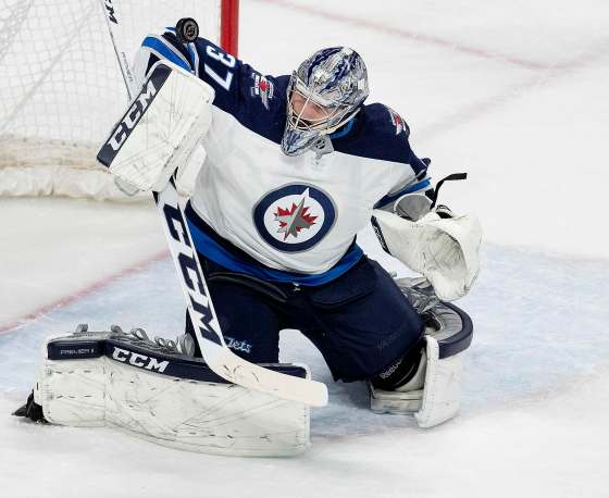 (Carlos Gonzalez/Minneapolis Star Tribune/TNS)Winnipeg Jets goalie Connor Hellebuyck, top, makes a save in Game 4 Tuesday.