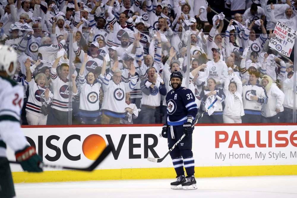 TREVOR HAGAN / WINNIPEG FREE PRESS Winnipeg Jets' Dustin Byfuglien (33) smiles after Joel Armia (40) deflects a shot past Minnesota Wild's goaltender Devan Dubnyk (40) during first action in game 5 of their playoff series, Friday, April 20, 2018.